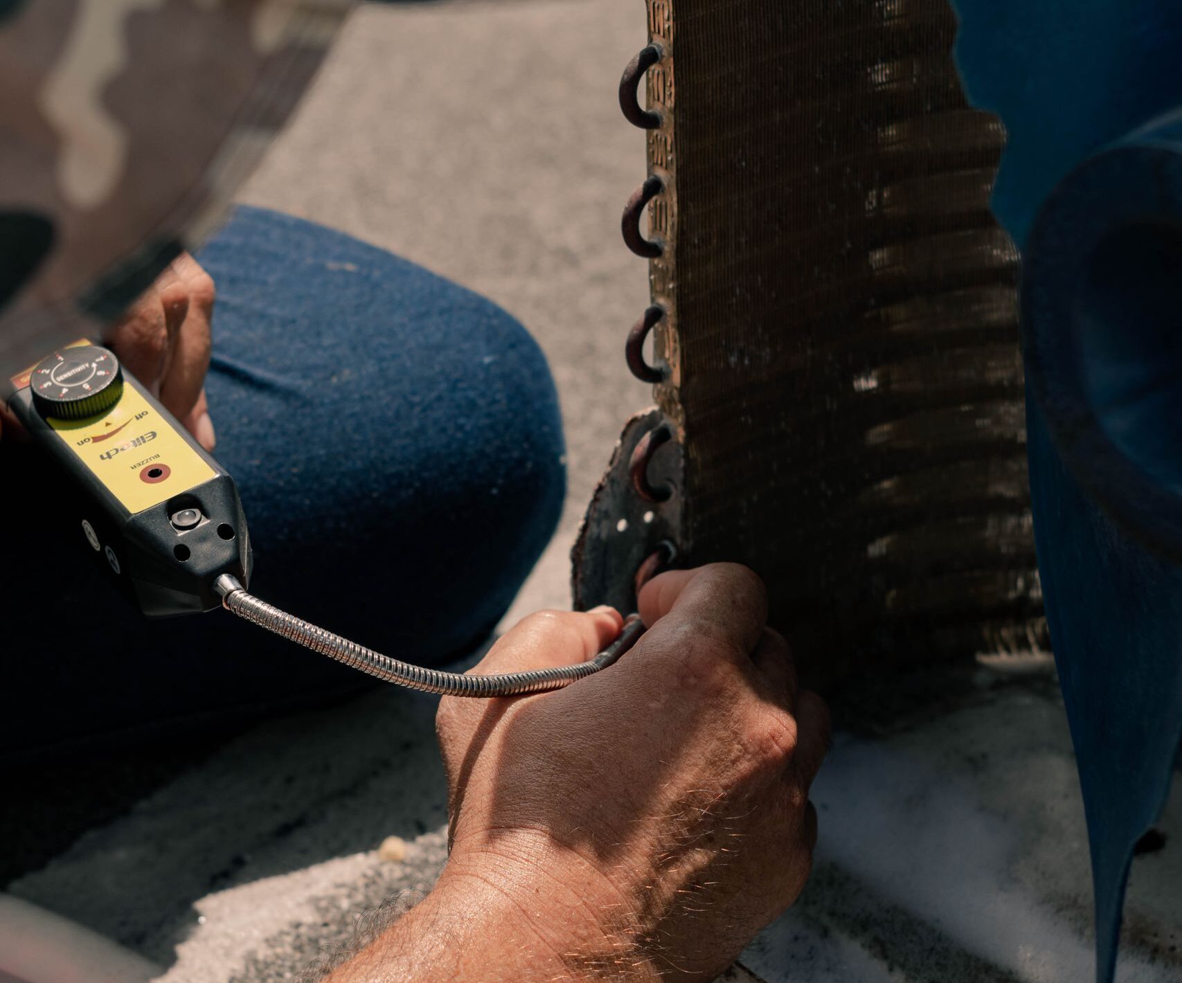 HVAC Technician repairing an air conditioner unit with tools